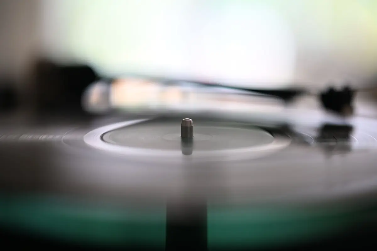 A turntable needle resting on a spinning record